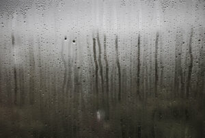 condensation on a residential glass window pane with a grey background
