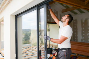 Male glazing specialist installing sliding glass window