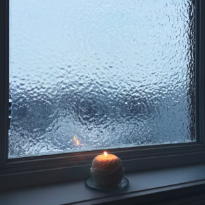 Candle in front of a frosted glass window