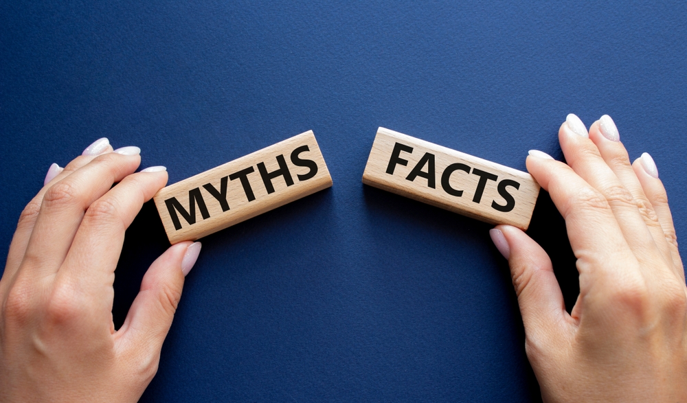 Hand holding blocks reading myths and facts on a blue background