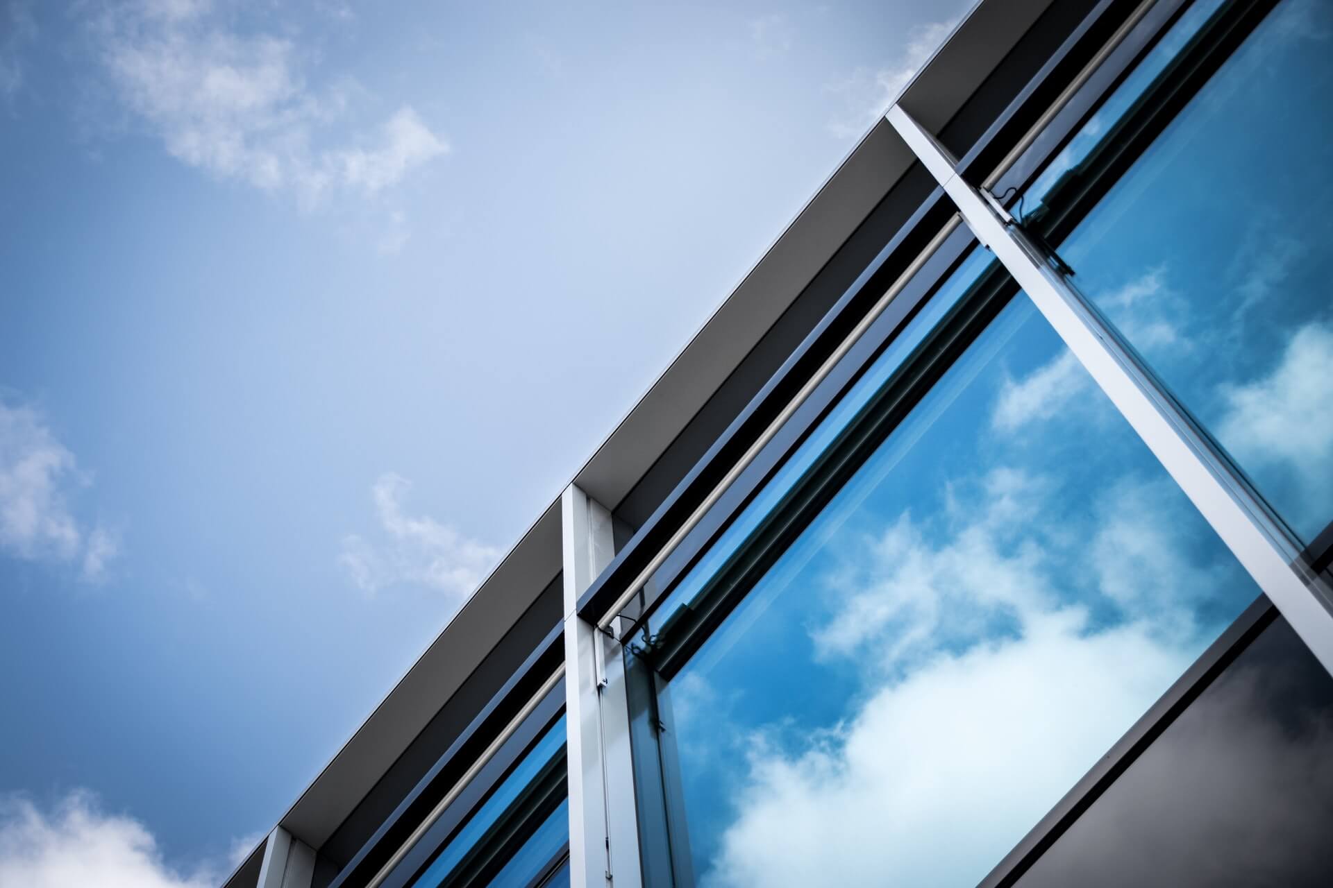 glass window panes reflecting blue sky and clouds