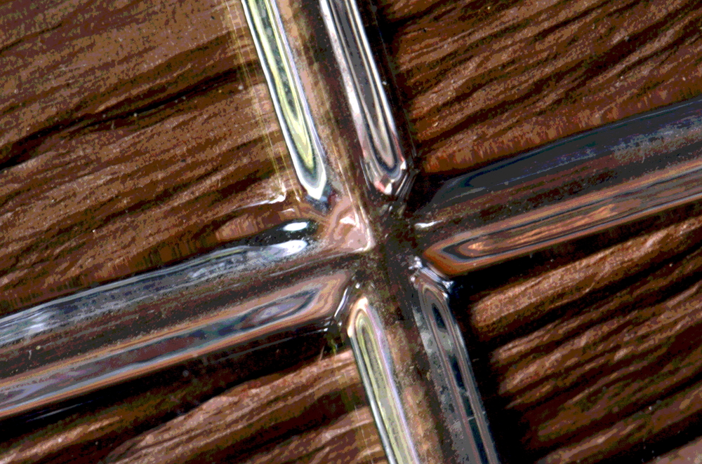 Close-up of beveled glass edges on a wood background