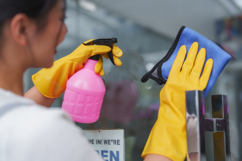Shopkeeper cleaning commercial safety and security glass